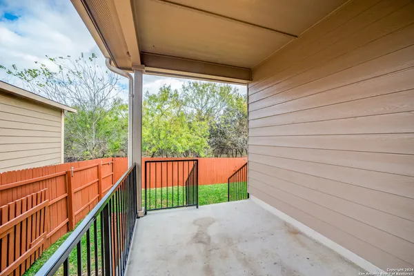 a view of a porch with wooden floor and iron fence
