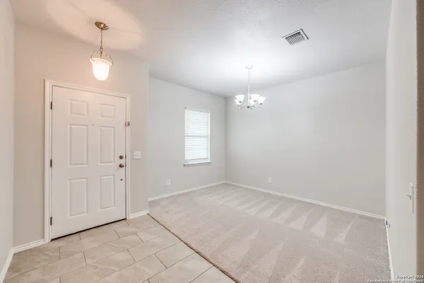 an empty room with fan and windows