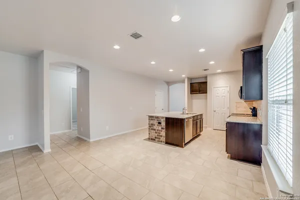 a view of kitchen with refrigerator cabinets and microwave