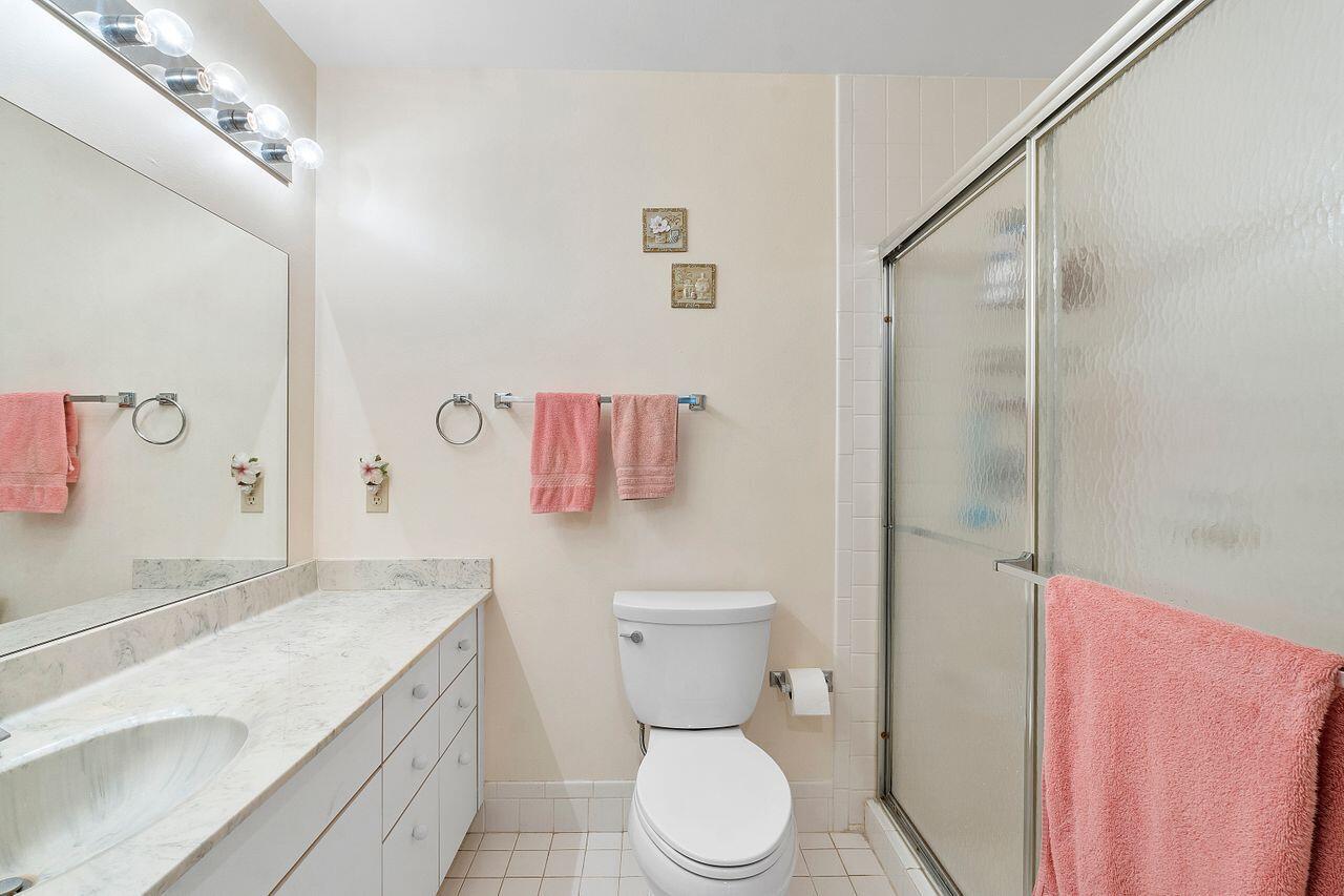 5130 Nesting Way, Unit D Delray Beach, FL 33484 - Photo 15 of 41 a bathroom with a granite countertop toilet sink and shower