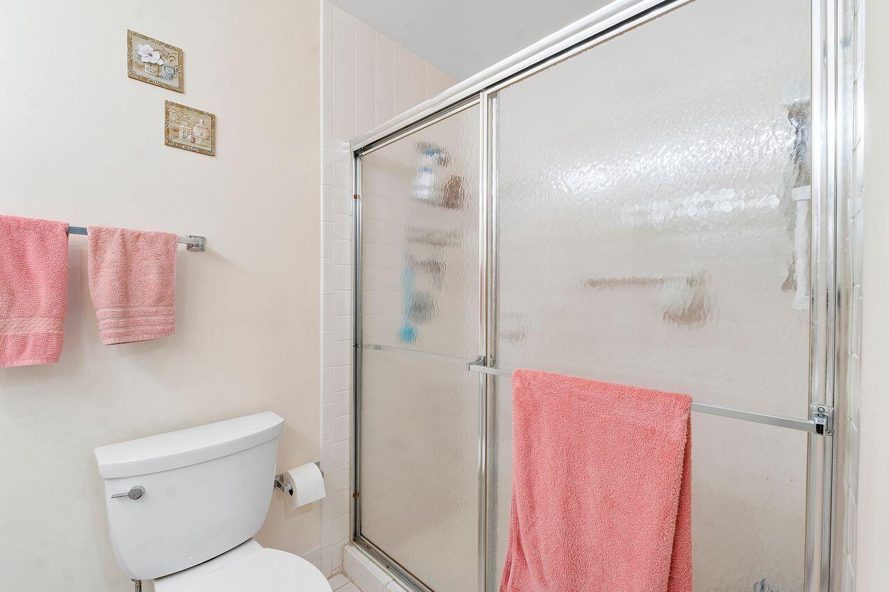 5130 Nesting Way, Unit D Delray Beach, FL 33484 - Photo 16 of 41 a white toilet sitting next to a bathroom sink