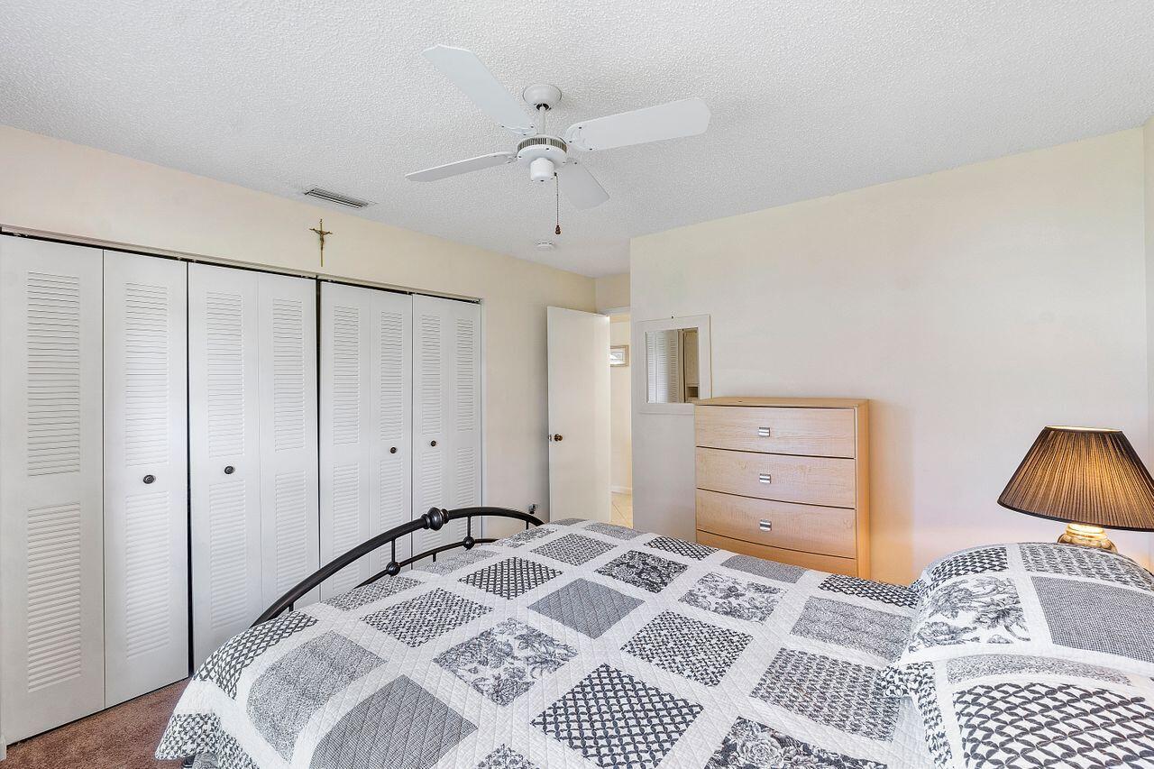 5130 Nesting Way, Unit D Delray Beach, FL 33484 - Photo 19 of 41 a bedroom with a bed and a dresser