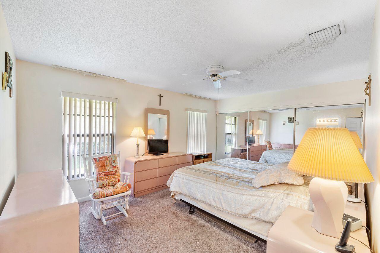 5130 Nesting Way, Unit D Delray Beach, FL 33484 - Photo 22 of 41 a bedroom with a bed and wooden floor