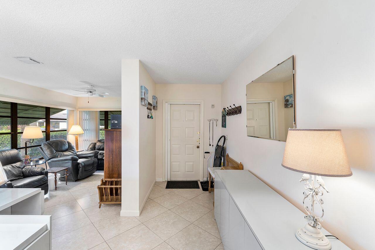 5130 Nesting Way, Unit D Delray Beach, FL 33484 - Photo 7 of 41 a bedroom with furniture and a lamp