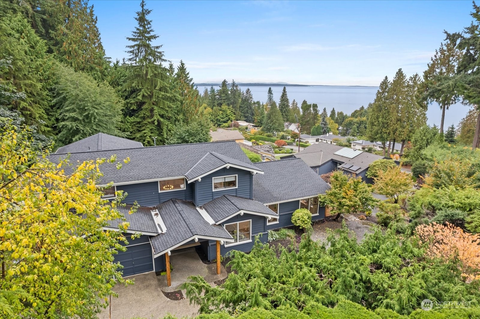an aerial view of residential houses with outdoor space and trees