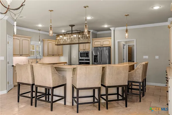 a kitchen with refrigerator and chairs