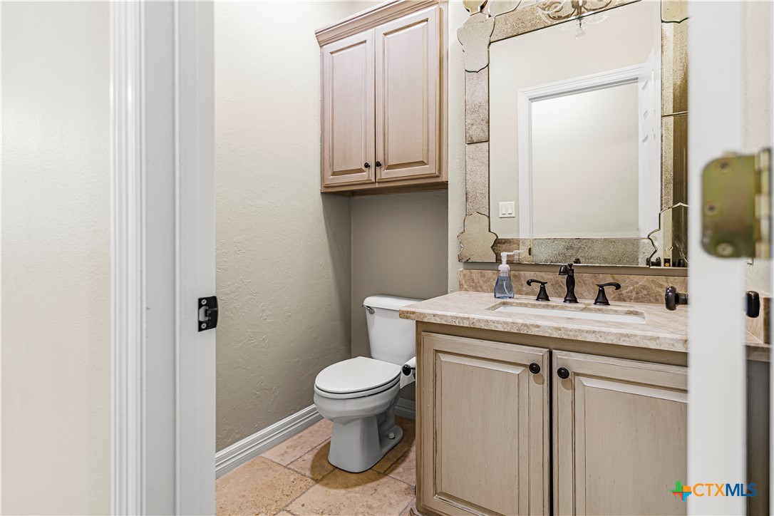 313 Treasure Oaks Road Inez, TX 77968 - Photo 18 of 47 a bathroom with a granite countertop toilet sink and mirror