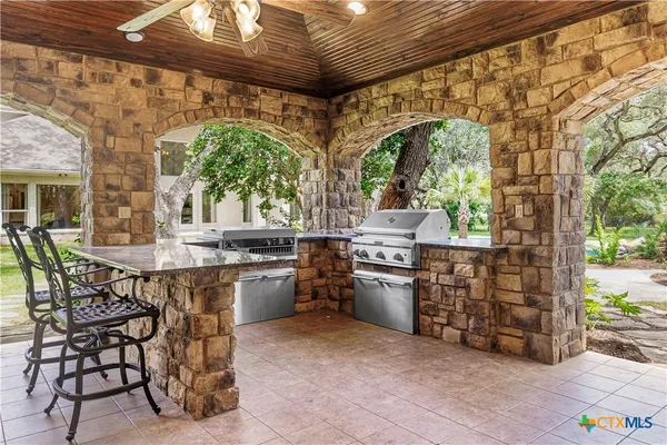 a kitchen with stainless steel appliances kitchen island granite countertop a table and chairs in it