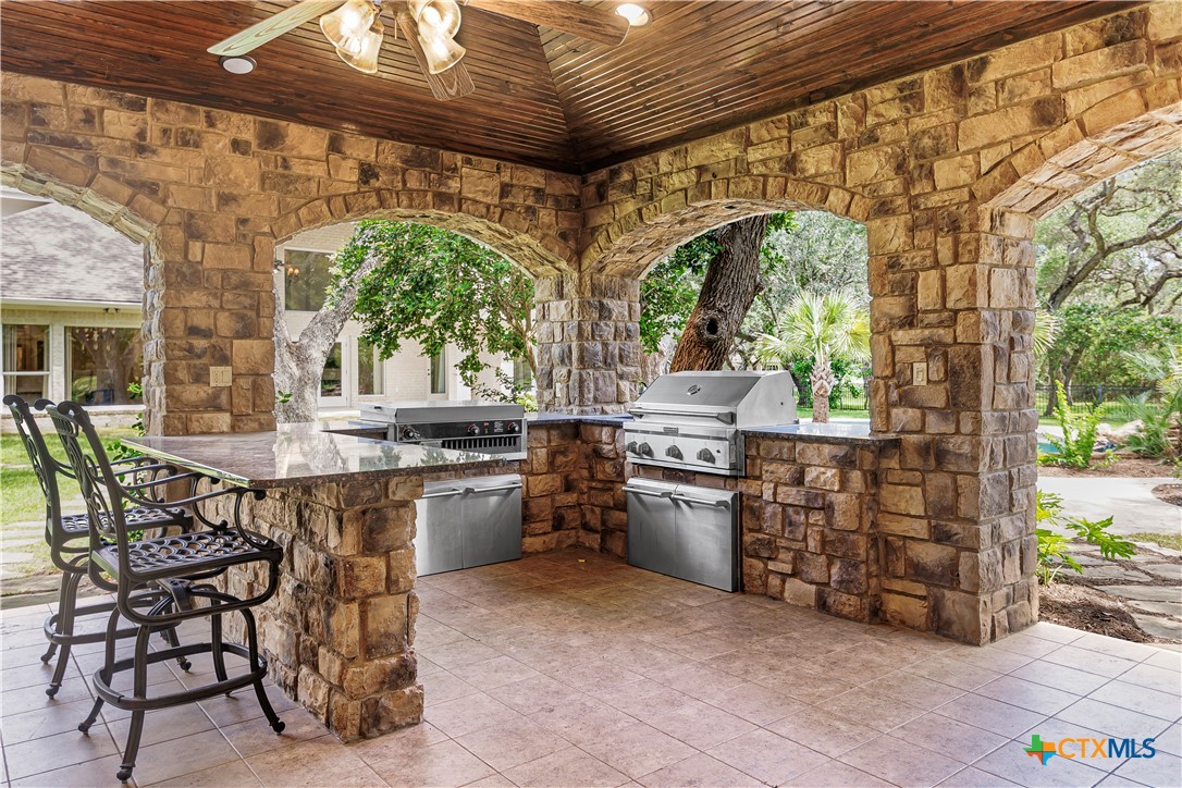 313 Treasure Oaks Road Inez, TX 77968 - Photo 29 of 47 a kitchen with stainless steel appliances kitchen island granite countertop a table and chairs in it