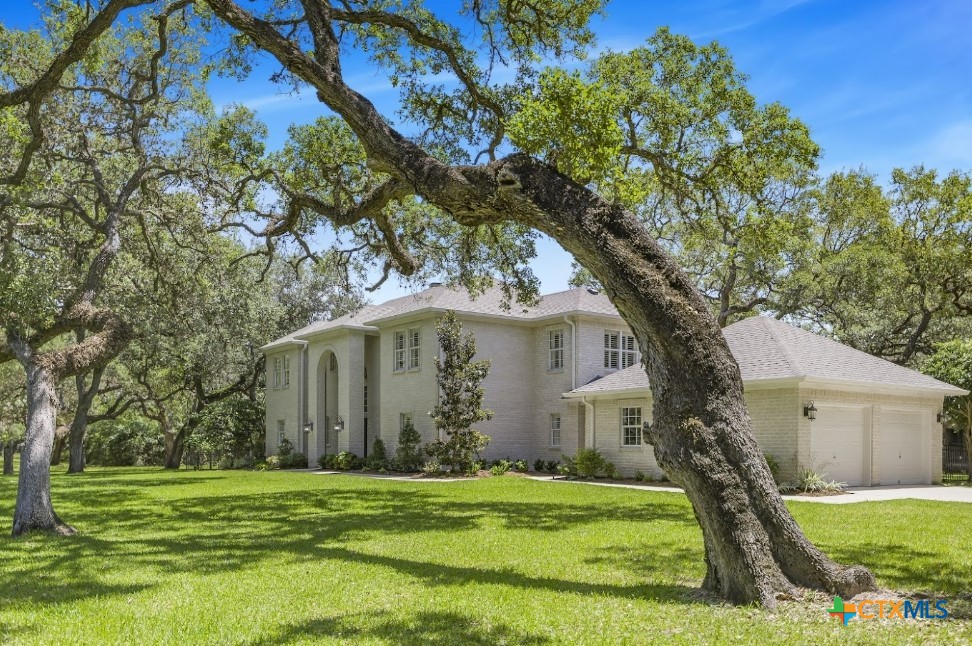 313 Treasure Oaks Road Inez, TX 77968 - Photo 4 of 47 a white house in a yard with large trees