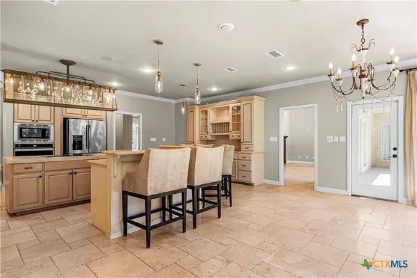 a large kitchen with granite countertop a table and chairs
