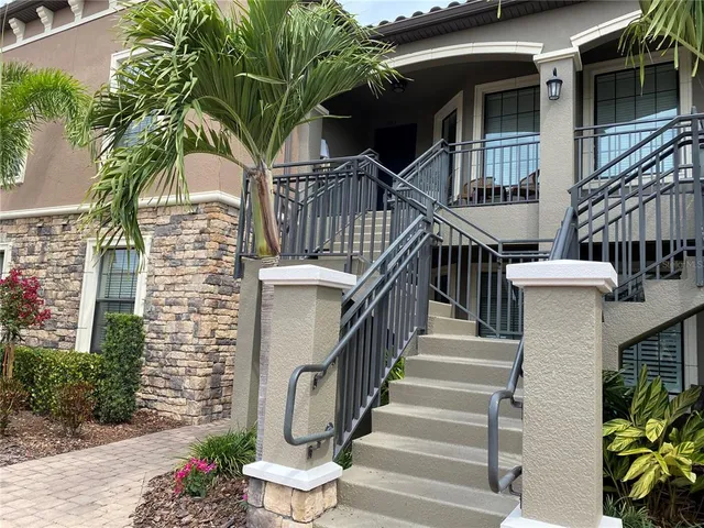 a view of a house with wooden stairs and floor to ceiling windows