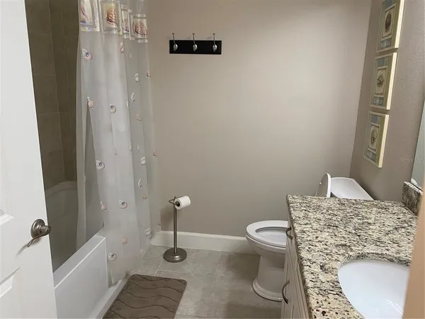 a bathroom with a granite countertop sink a toilet and a mirror