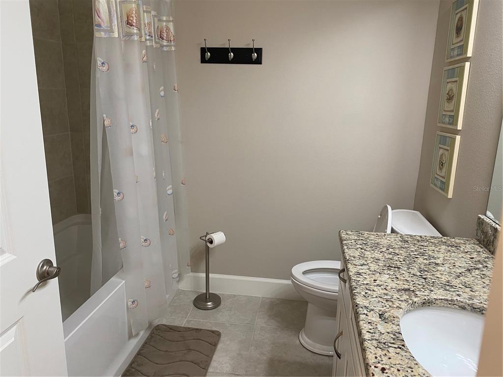 13711 Messina Loop, Unit 203 Lakewood Ranch, FL 34211 - Photo 23 of 27 a bathroom with a granite countertop toilet and a sink