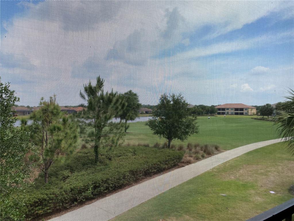 13711 Messina Loop, Unit 203 Lakewood Ranch, FL 34211 - Photo 25 of 27 a view of a lake with a yard