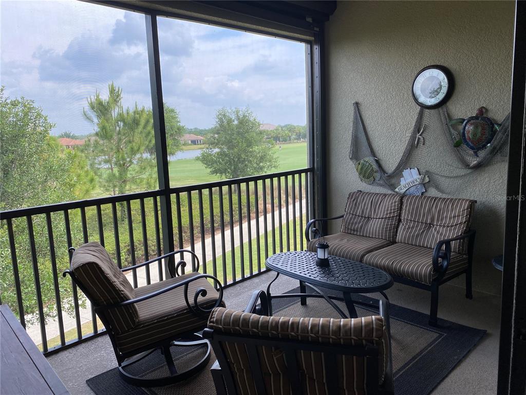13711 Messina Loop, Unit 203 Lakewood Ranch, FL 34211 - Photo 26 of 27 a living room with furniture and a floor to ceiling window