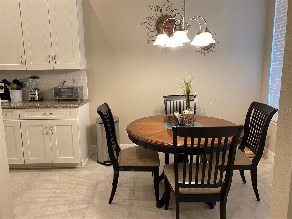 13711 Messina Loop, Unit 203 Lakewood Ranch, FL 34211 - Photo 4 of 27 a view of a dining room with furniture and wooden floor