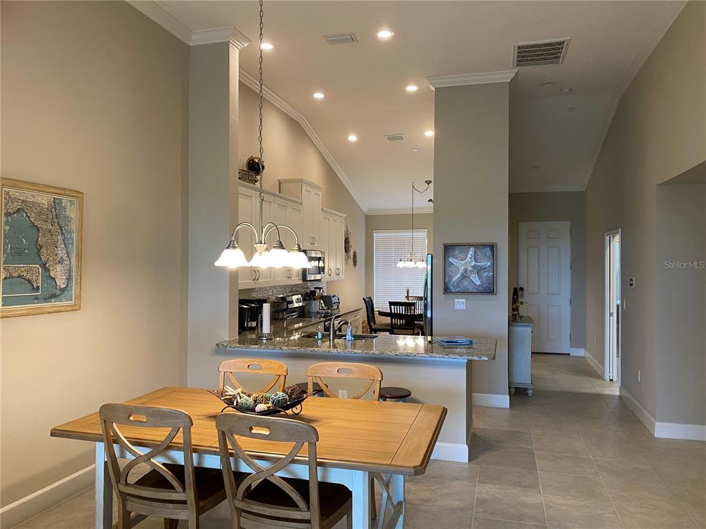 13711 Messina Loop, Unit 203 Lakewood Ranch, FL 34211 - Photo 9 of 27 a view of a dining room with furniture and wooden floor