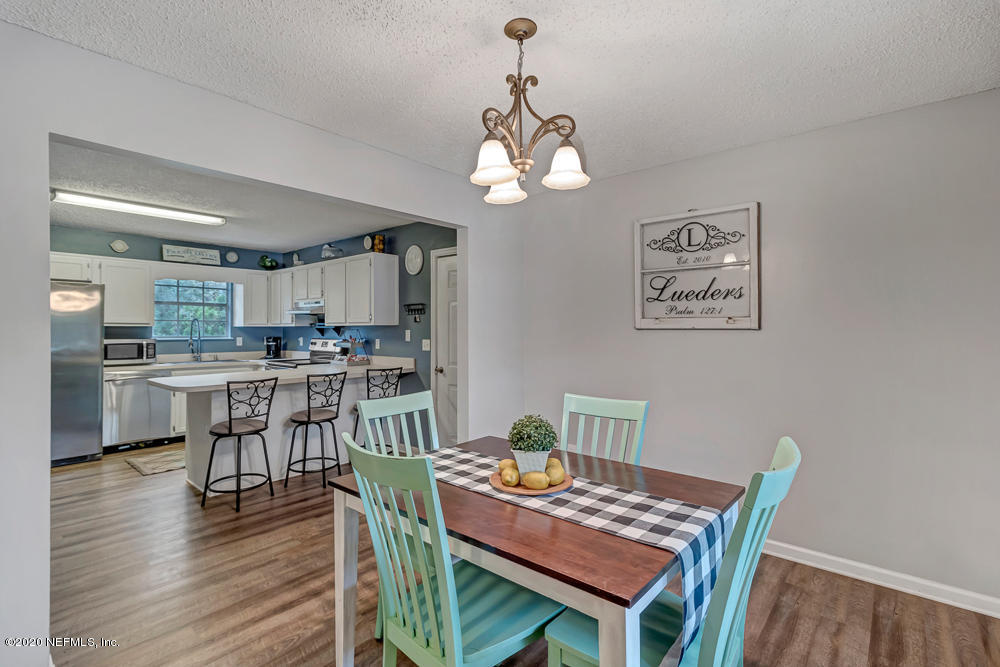 54071 Armstrong Road Callahan, FL 32011 - Photo 7 of 26 a view of a dining room with furniture wooden floor and a chandelier