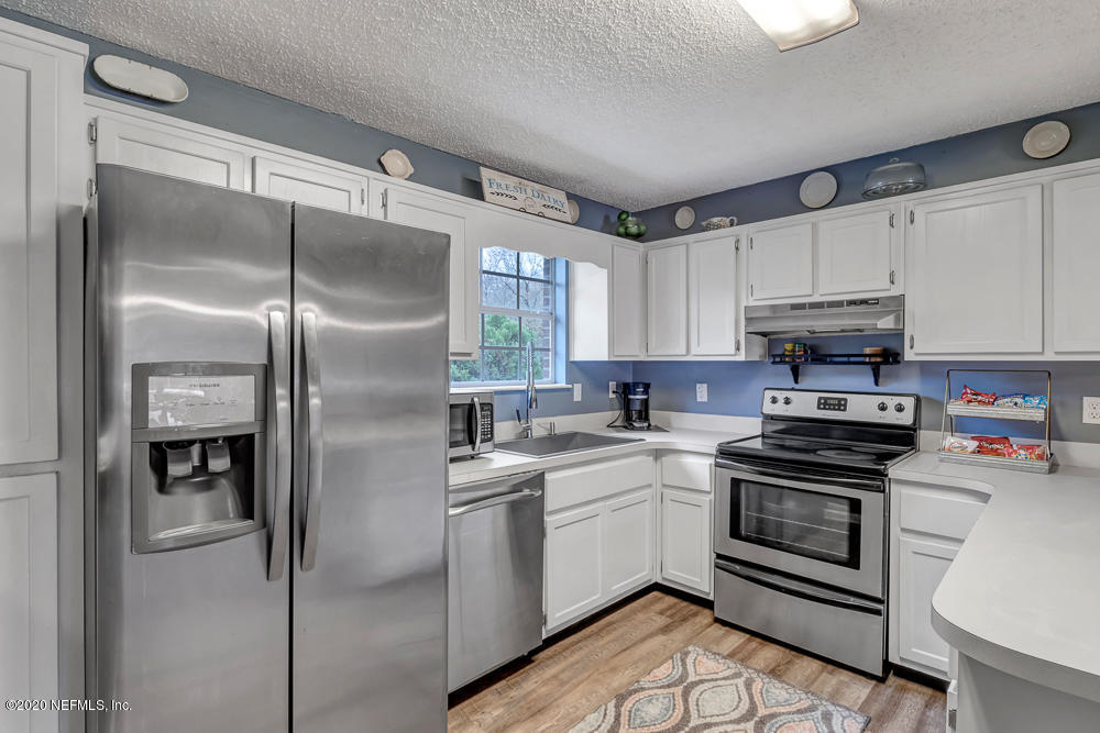 54071 Armstrong Road Callahan, FL 32011 - Photo 9 of 26 a kitchen with a refrigerator a sink and cabinets