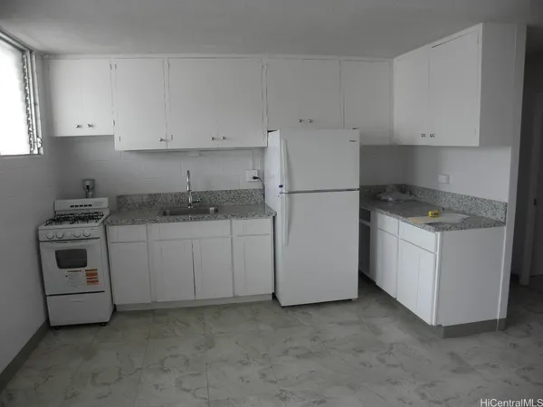 a kitchen with white cabinets and white appliances