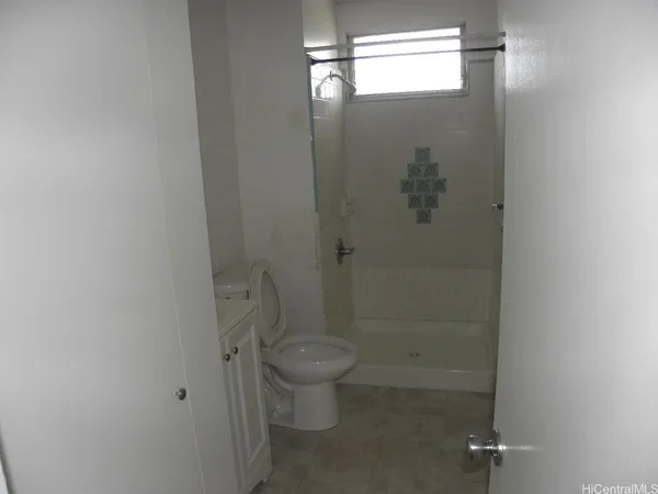 a bathroom with a granite countertop toilet and a shower