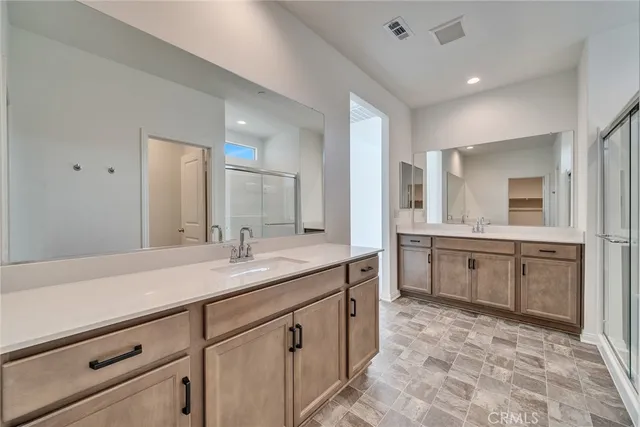 a spacious bathroom with a granite countertop sink mirror and cabinets
