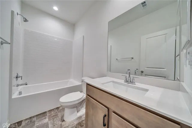 a bathroom with a sink a toilet and a large mirror