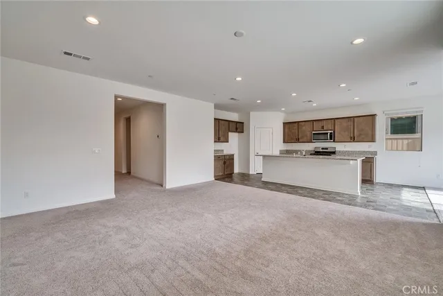 a view of a kitchen with a sink wooden cabinets and a window