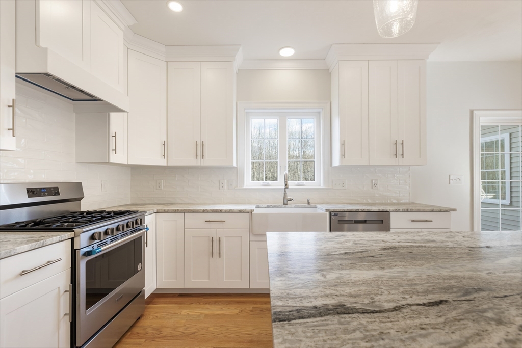 Lot 30 May Road Millis, MA 02054 - Photo 13 of 31 a kitchen with stainless steel appliances granite countertop a stove a sink and white cabinets