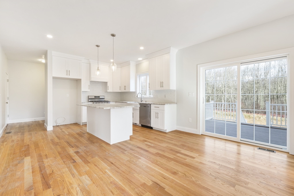 Lot 30 May Road Millis, MA 02054 - Photo 9 of 31 a kitchen with stainless steel appliances kitchen island hardwood floor sink and stove
