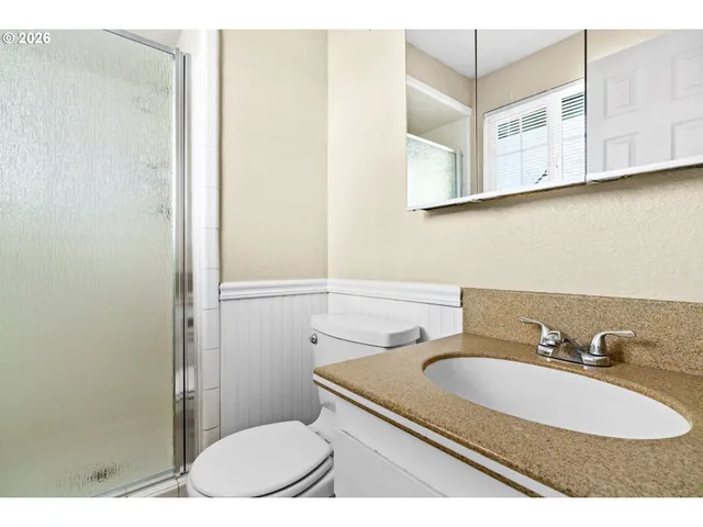 a bathroom with a sink a toilet and shower