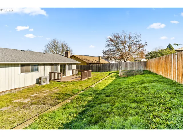 a view of a house with a big yard and large tree