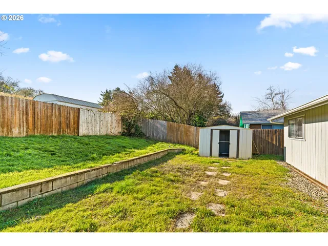 a view of a backyard with floor to ceiling window and wooden fence