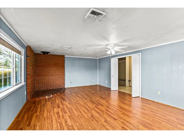 wooden floor in an empty room with a window
