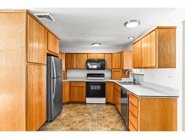 a kitchen with stainless steel appliances granite countertop a refrigerator a sink dishwasher with a dining table and chairs