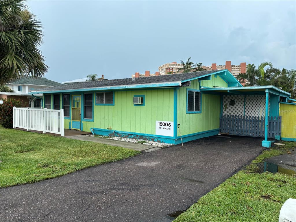 18006 4th Street East Redington Shores, FL 33708 - Photo 2 of 32 a front view of a house with a garden and plants