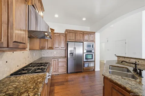 a kitchen with stainless steel appliances granite countertop a refrigerator and a stove