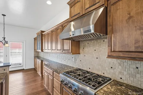 a kitchen with granite countertop a stove and cabinets