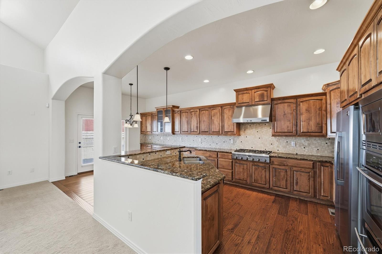 477 Rifle Way Broomfield, CO 80020 - Photo 15 of 45 a kitchen that has a sink a stove and a wooden cabinets