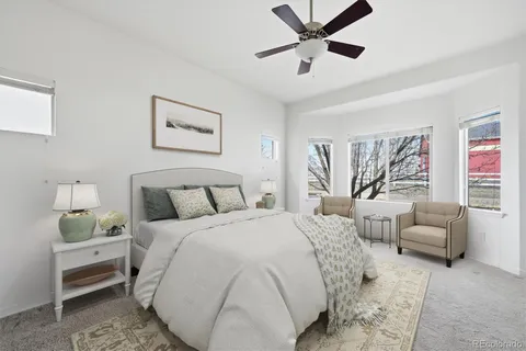 a spacious bedroom with a bed a couch and a window