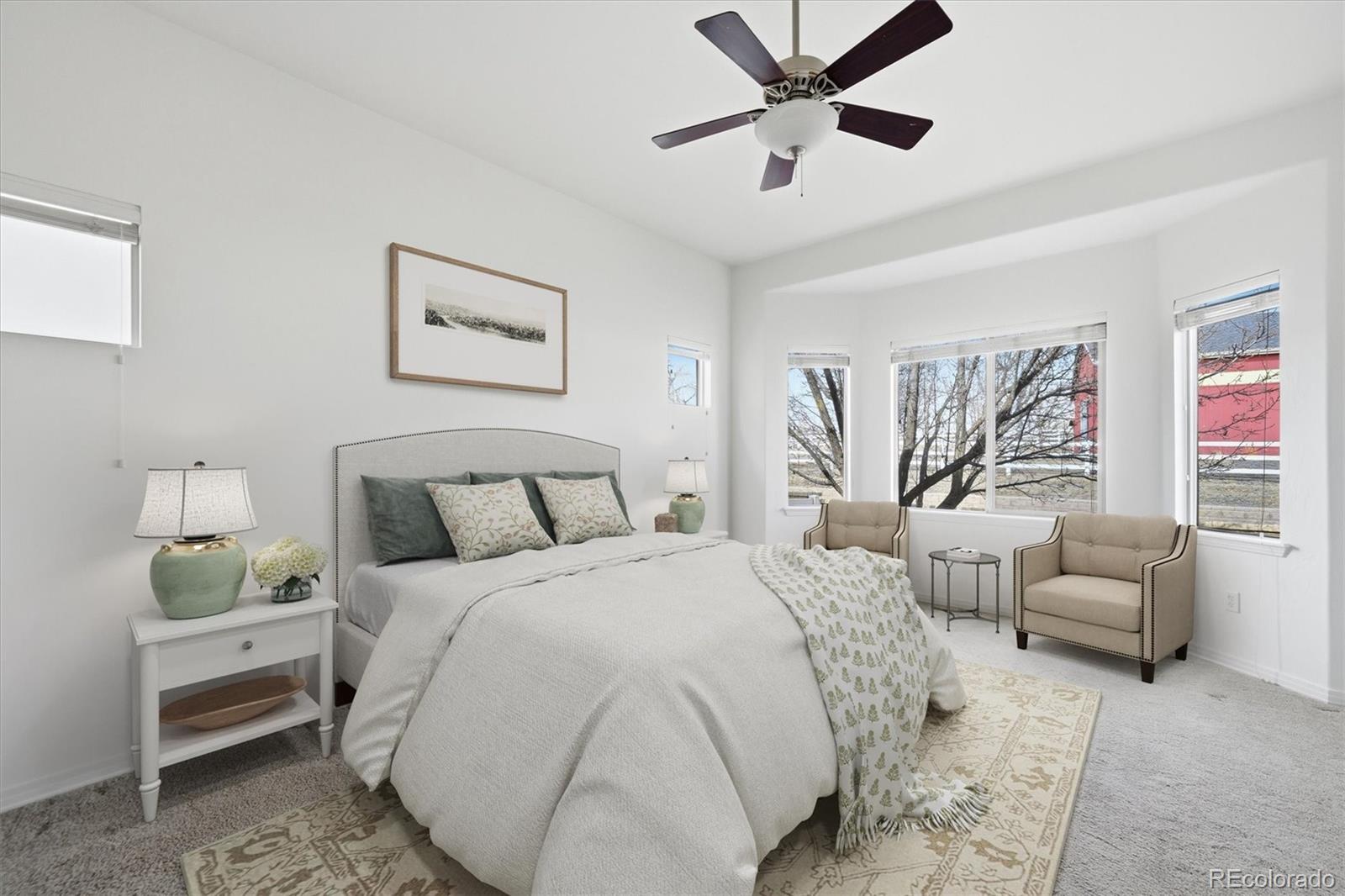 477 Rifle Way Broomfield, CO 80020 - Photo 16 of 45 a spacious bedroom with a bed a couch and a window