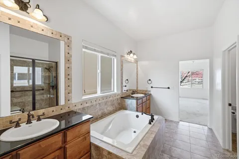 a bathroom with a tub sink and mirror
