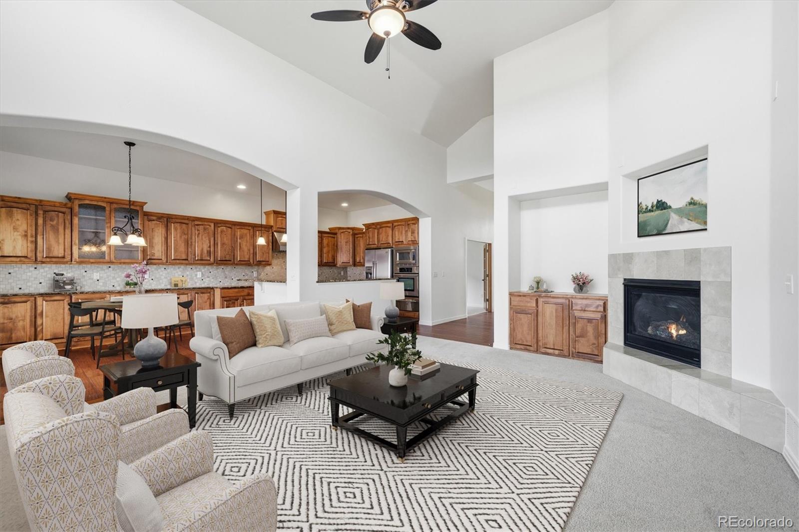 477 Rifle Way Broomfield, CO 80020 - Photo 3 of 45 a living room with furniture a fireplace and a chandelier
