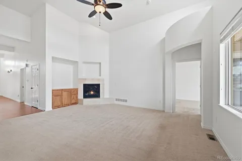 a view of an empty room with a fireplace and a window
