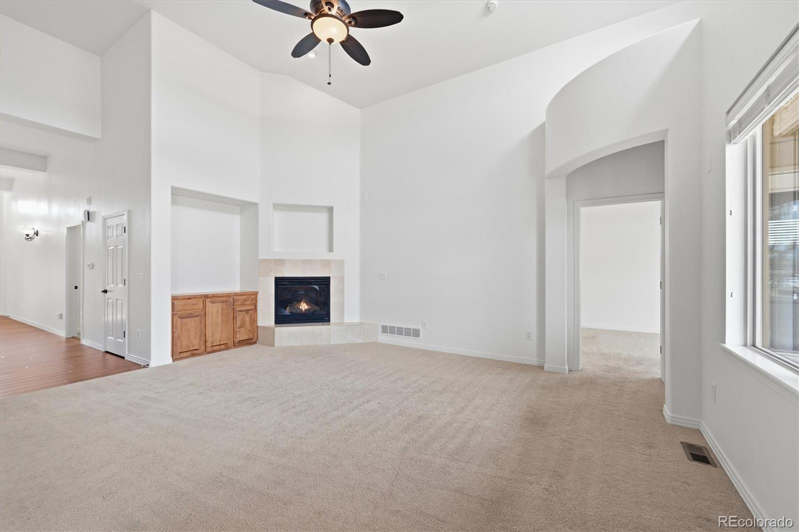 477 Rifle Way Broomfield, CO 80020 - Photo 5 of 45 a view of an empty room with a fireplace and a window