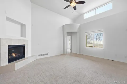 a view of an empty room with window and fireplace