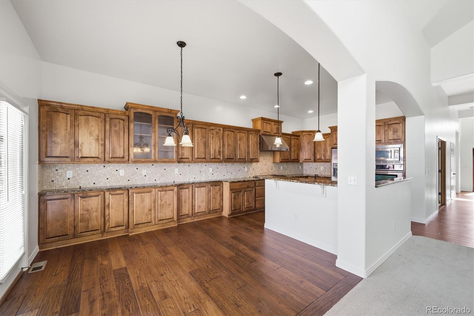 477 Rifle Way Broomfield, CO 80020 - Photo 9 of 45 a large kitchen with granite countertop a large counter top a sink stainless steel appliances and cabinets