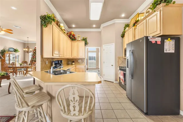 a large kitchen with stainless steel appliances kitchen island granite countertop a refrigerator and a stove