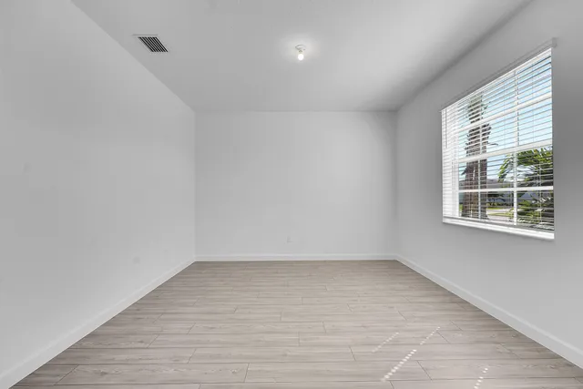wooden floor in an empty room with a window